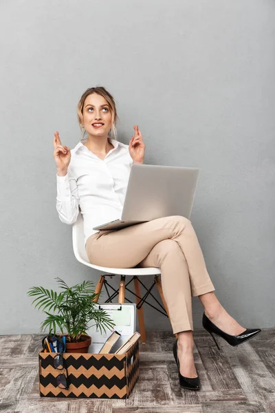 Retrato de mulher elegante usando laptop enquanto sentado na cadeira wi — Fotografia de Stock