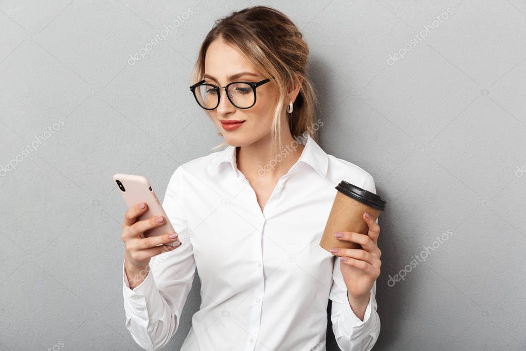 Portrait of european businesswoman wearing glasses holding smart