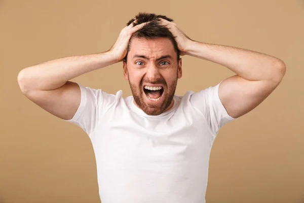 Portrait of a confused young man holding arms — Stock Photo, Image