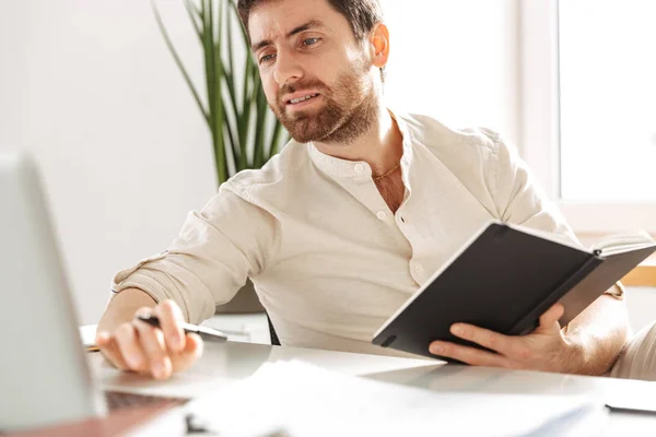 Image of serious office worker 30s wearing white shirt using lap — Stock Photo, Image