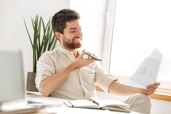 Imagen del alegre hombre de negocios de 30 años con camisa blanca hablando en m — Foto de Stock