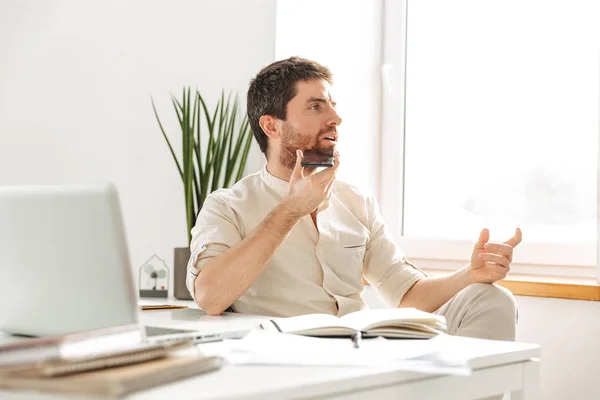 Imagen del empresario concentrado de 30 años con camisa blanca talkin — Foto de Stock