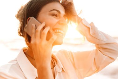 Avrupa kadın 20'li yaşlarda görüntü gülümseyen ve cep telefonu, w konuşuyor