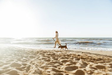 Onun kahverengi köpek al ile çalışan hasır şapkalı mutlu kadın görüntüsünü