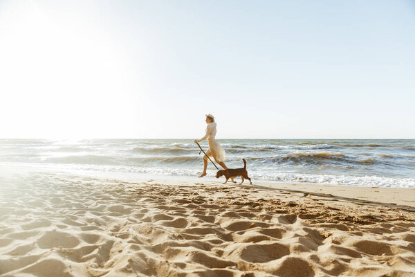 Image of happy woman in straw hat, running with her brown dog al — Stock Photo, Image