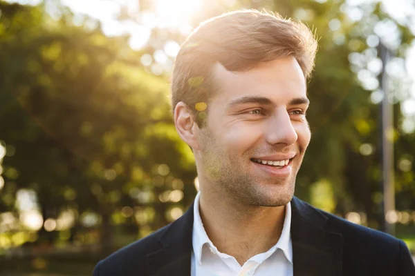 Primer plano de un joven hombre de negocios sonriente caminando —  Fotos de Stock