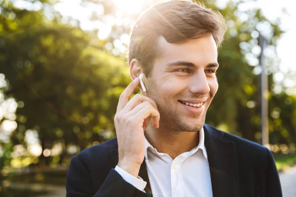 Primer plano de un joven hombre de negocios sonriente caminando —  Fotos de Stock