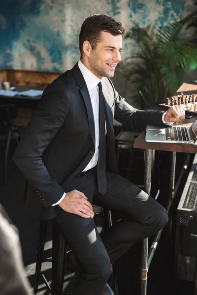 Schöner junger Geschäftsmann in formeller Kleidung drinnen in einem Café mit Laptop-Computer. — Stockfoto