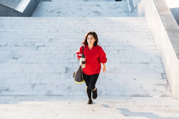 Glimlachend jonge Sportvrouw dragen een hoodie wandelen — Stockfoto