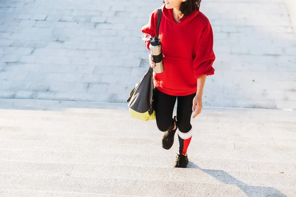 Joven deportista sonriente con una sudadera con capucha caminando —  Fotos de Stock