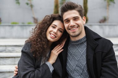 Görüntü güzel çift erkek ve kadın 20'li yaşlarda sıcak giysiler içinde huggin