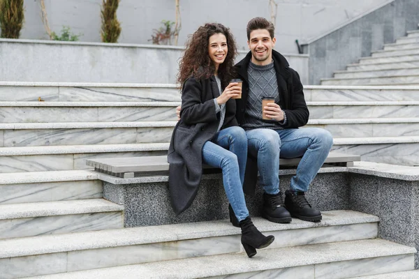 Imagen de pareja joven hombre y mujer de 20 años en ropa de abrigo, drinkin —  Fotos de Stock