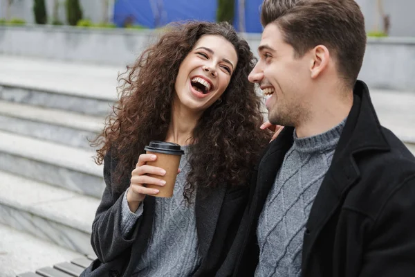 Foto van de gelukkige paar man en vrouw 20s in warme kleren, drinkin — Stockfoto