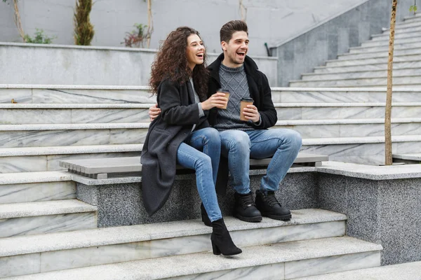 Immagine di giovane uomo e donna soddisfatti 20s in abiti caldi, drin — Foto Stock