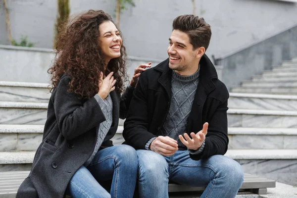 Obrázek radostné pár muž a žena 20s v teplé oblečení, laughi — Stock fotografie
