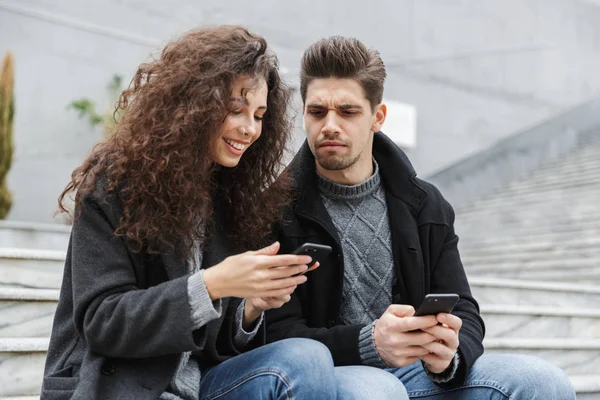 Afbeelding van een mooi paar man en vrouw 20s in warme kleren, usi — Stockfoto