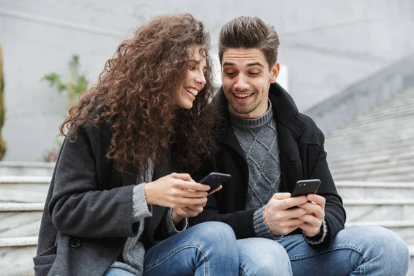 Afbeelding van brunette paar man en vrouw 20s in warme kleren, usin — Stockfoto