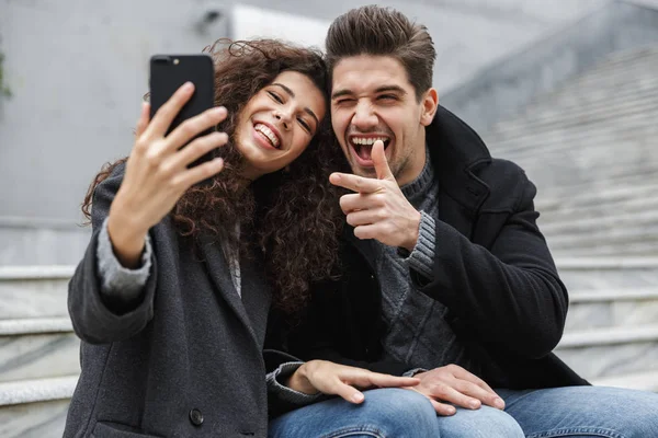 Imagem do belo casal homem e mulher 20s em roupas quentes, tak — Fotografia de Stock