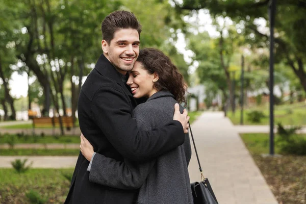 Image of adorable couple man and woman 20s hugging, and walking — Stock Photo, Image