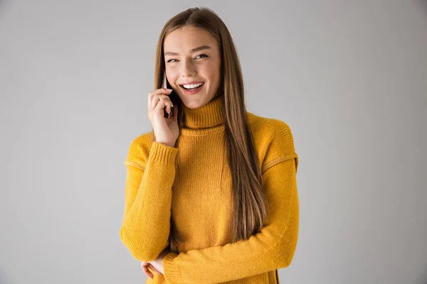 Szczęśliwa młoda kobieta na białym tle szarej ścianie rozmawia przez telefon komórkowy. — Zdjęcie stockowe