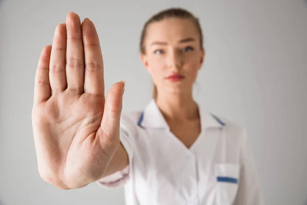 Hermosa joven cosmetóloga médico aislado sobre fondo gris de la pared mostrando gesto de stop . — Foto de Stock