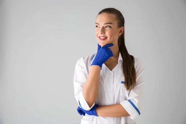 Belle jeune femme cosmétologue médecin isolé sur fond de mur gris . — Photo