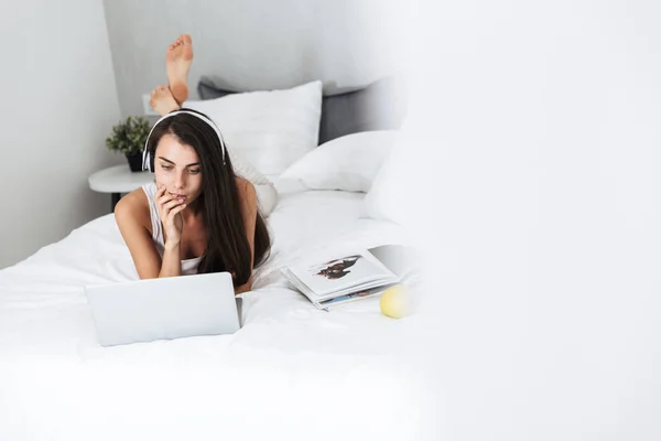 Schöne junge Frau entspannt auf dem Bett zu Hause — Stockfoto