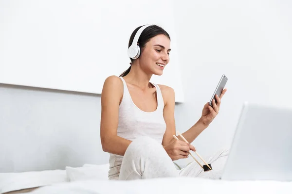 Beautiful young woman relaxing on bed at home — Stock Photo, Image