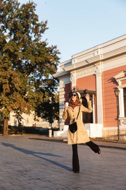 Mutlu genç güzel kadın açık havada içki kahve street yürüyüş.