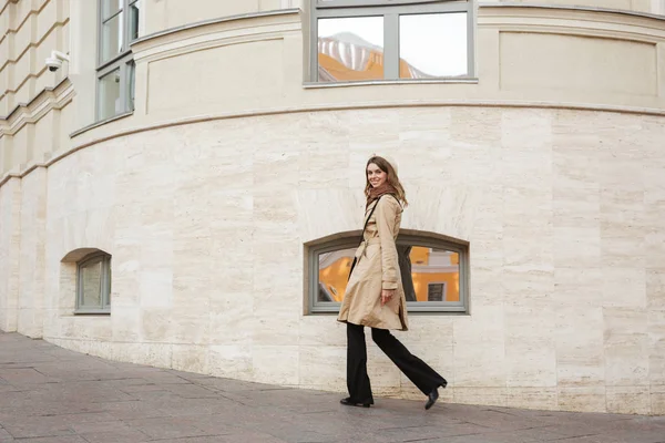 Mooie jonge vrouw die het dragen van een jas lopen — Stockfoto