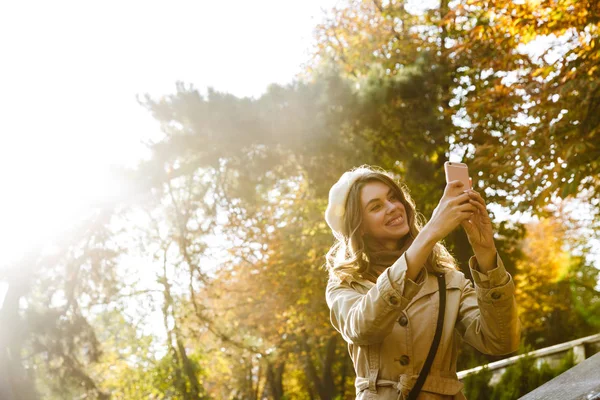 Emocionado joven hermosa mujer al aire libre en el parque de la calle tomar una selfie por teléfono móvil . —  Fotos de Stock