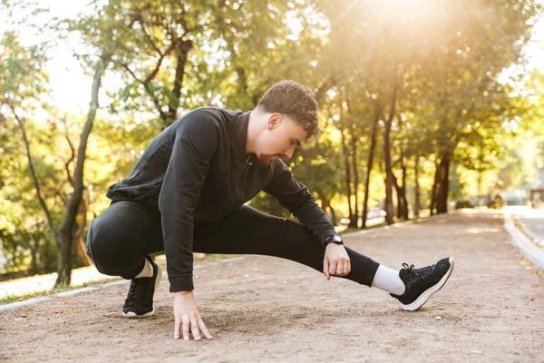 Hübsche junge Sport Fitness Mann Läufer im Freien im Park machen Übungen. — Stockfoto