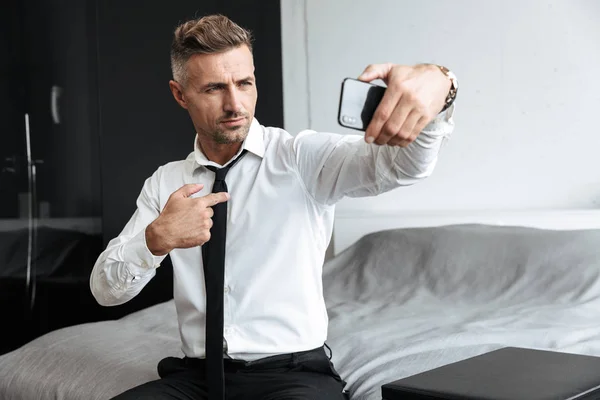 Guapo hombre de negocios confiado tomando una selfie — Foto de Stock