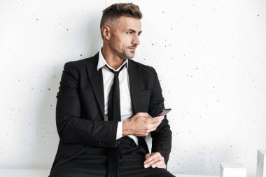 Cep telefonu kullaranarak beyaz duvar arka plan üzerinde izole poz iş adamı.