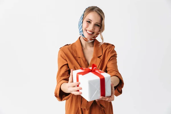 Gelukkig jonge vrouw die het dragen van zijden stijlvolle sjaal poseren geïsoleerd over witte muur achtergrond houden geschenkdoos. — Stockfoto