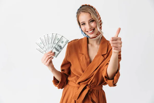 Schöne aufgeregte junge blonde hübsche Frau trägt Seidentuch posiert isoliert über weißen Wand Hintergrund hält Geld. — Stockfoto