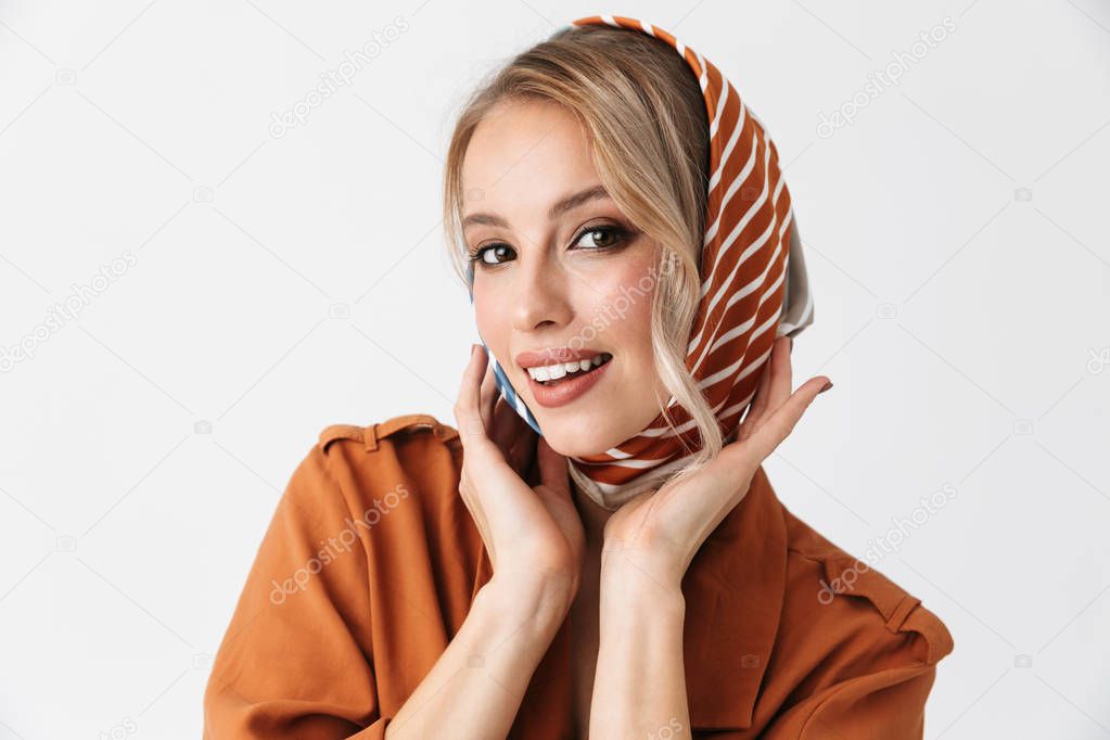 Happy young blonde pretty woman wearing silk scarf posing isolated over white wall background.