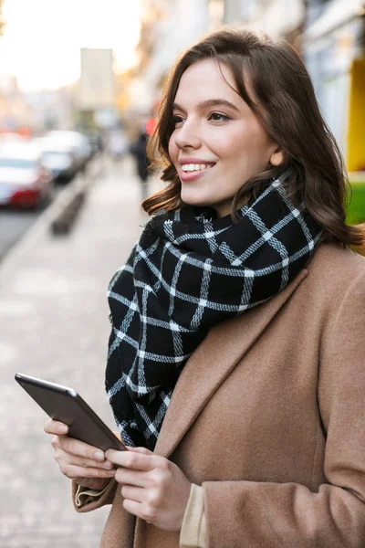Счастливая молодая женщина, пользующаяся планшетным компьютером на улице . — стоковое фото