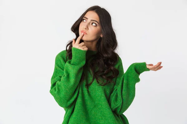 Hermosa mujer joven pensando vestida con suéter verde posando aislada sobre fondo blanco de la pared . —  Fotos de Stock