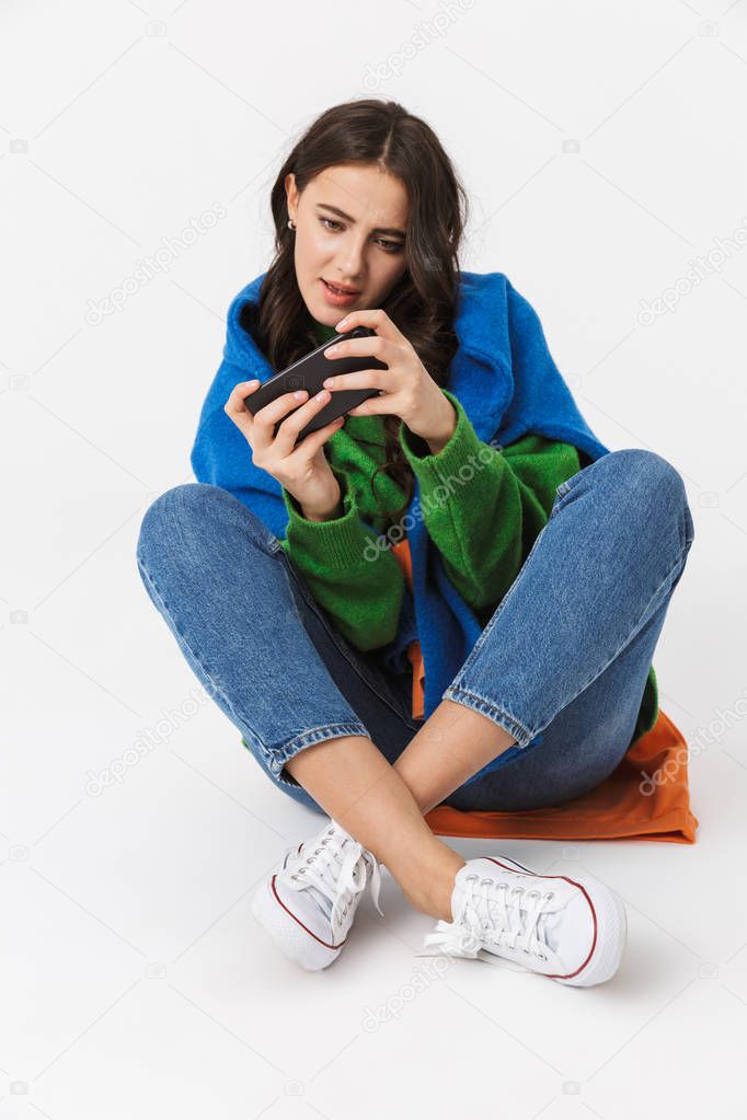 Image of cheerful woman 30s in colorful clothes sitting on the f