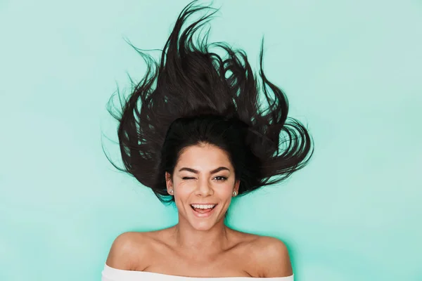 Hermosa joven se encuentra aislada sobre fondo azul claro. Concepto de cabello saludable . — Foto de Stock