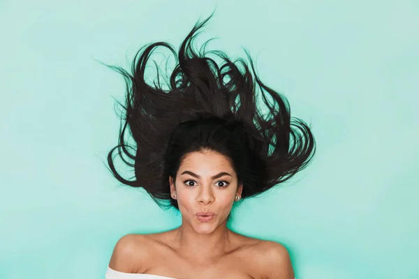 Jovem chocada encontra-se isolada no fundo de luz azul. Conceito de cabelo saudável . — Fotografia de Stock