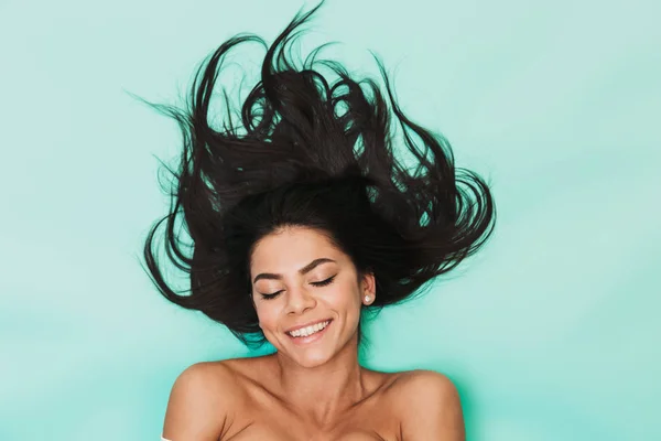 Hermosa joven se encuentra aislada sobre fondo azul claro. Concepto de cabello saludable . — Foto de Stock