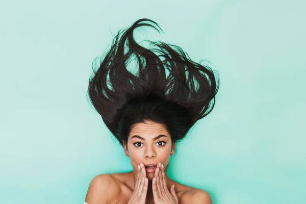 Jovem chocada encontra-se isolada no fundo de luz azul. Conceito de cabelo saudável . — Fotografia de Stock