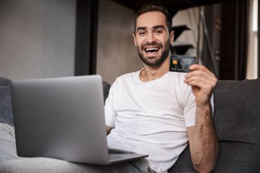Mutlu genç adam bir kanepede oturan
