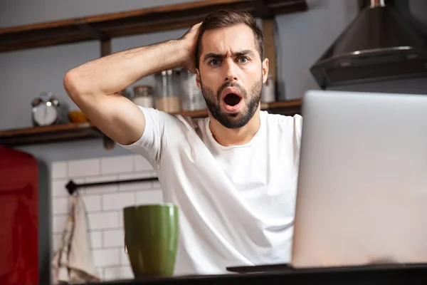 Joven sorprendido usando ordenador portátil — Foto de Stock