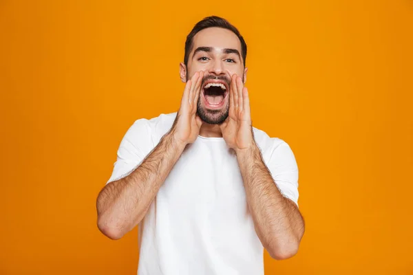 Imagen del atractivo hombre de 30 años en camiseta mientras llama o grita — Foto de Stock