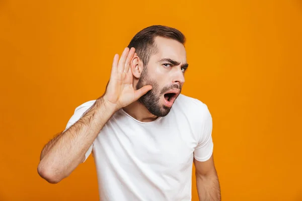 Imagem do homem europeu 30 anos tentando ouvir algo enquanto mantendo — Fotografia de Stock