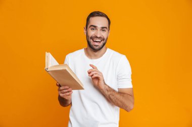 Görüntü gülümseyen adam 30'lu yaşlarda beyaz t-shirt tutarak ve bo okuma