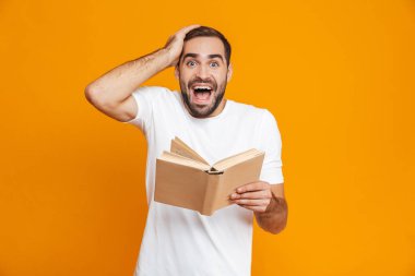 Bıyıklı adam 30'lu yaşlarda beyaz t-shirt tutarak ve okuma görüntüsünü 